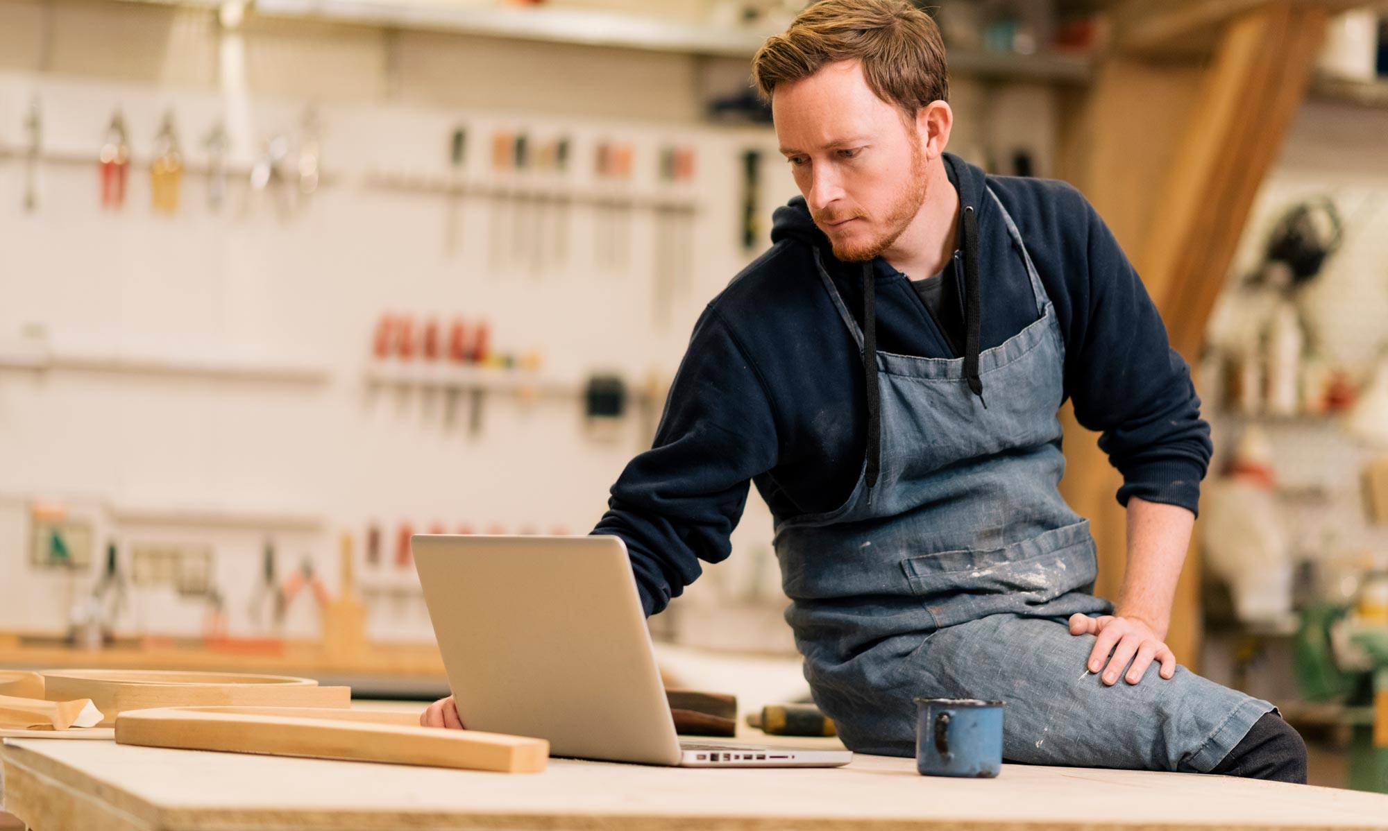 En man i en verkstad som läser i en dator