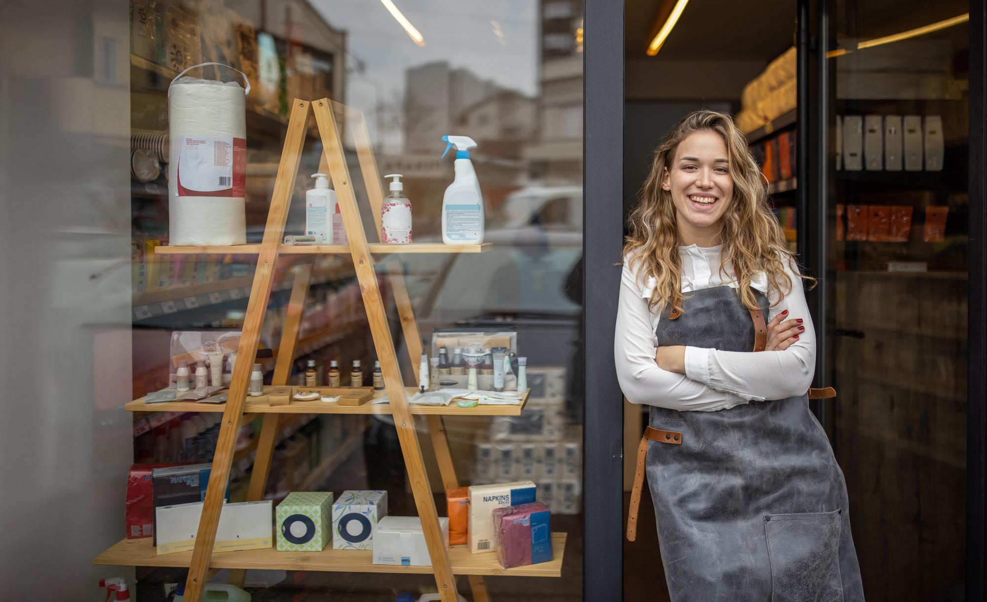 Kvinna som står utanför sin butik och ler