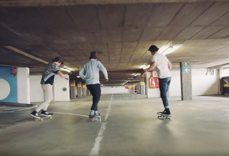 Tre personer åker skateboard i ett parkeringshus