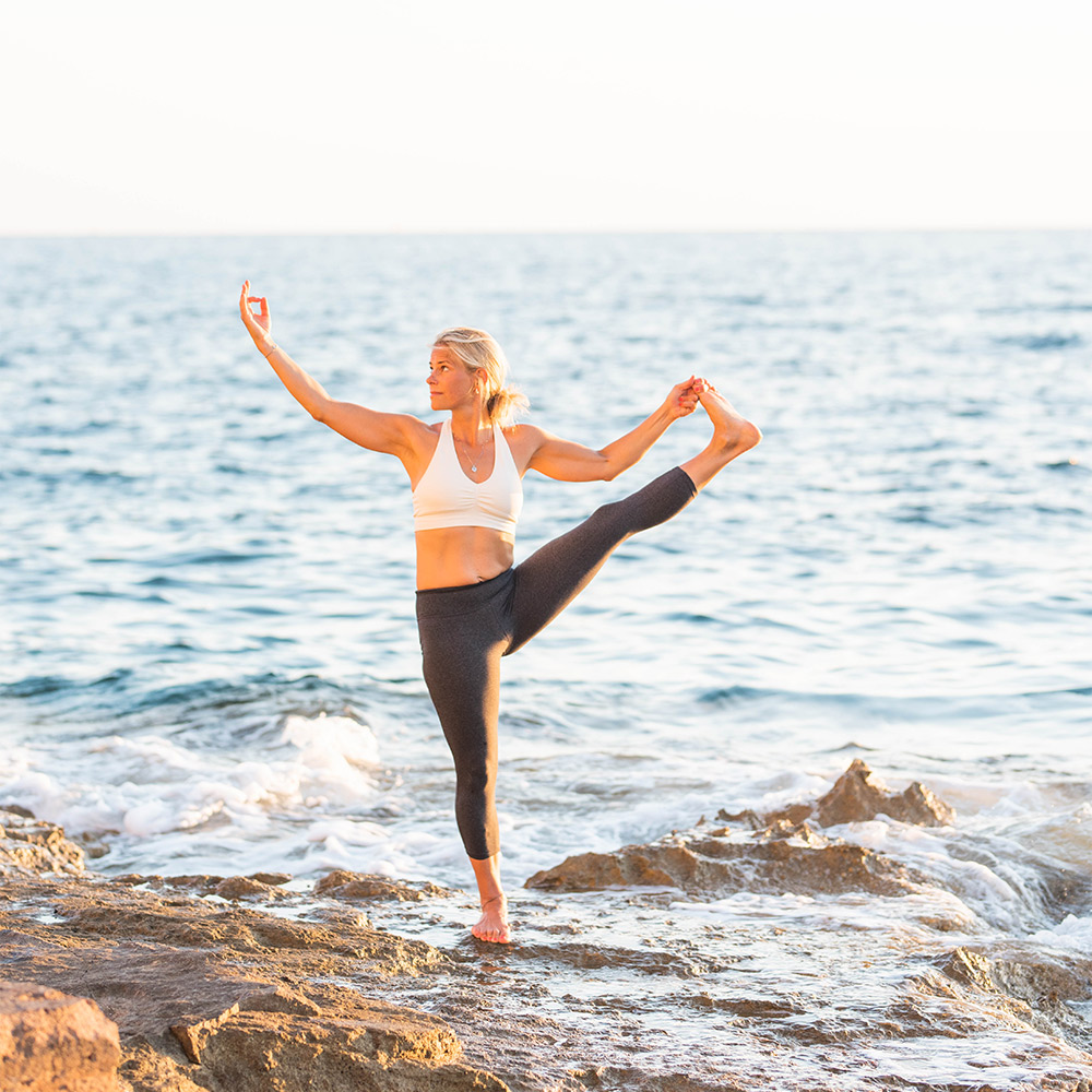 Charlotte Fredriksson gör yoga vid vattnet.