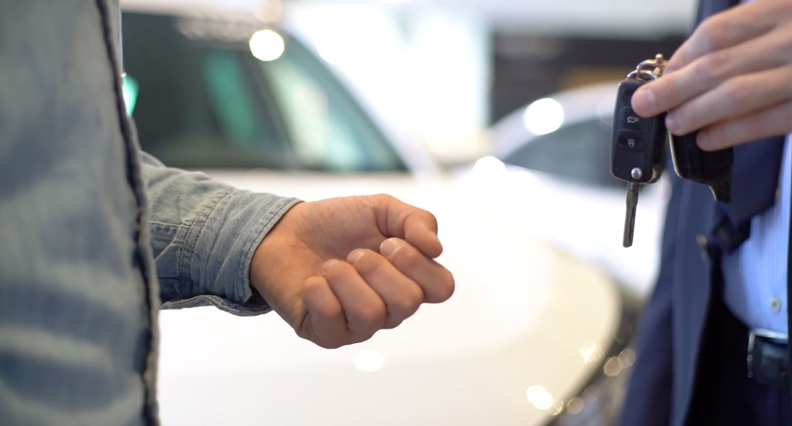 En person räcker över ett par bilnycklar