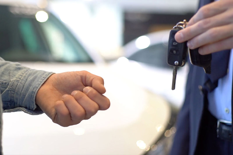 En person räcker över ett par bilnycklar