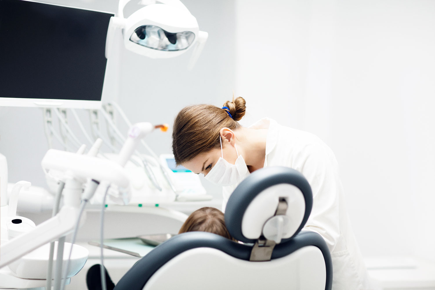En tandläkare som gör undersökning av patient i en modern miljö.