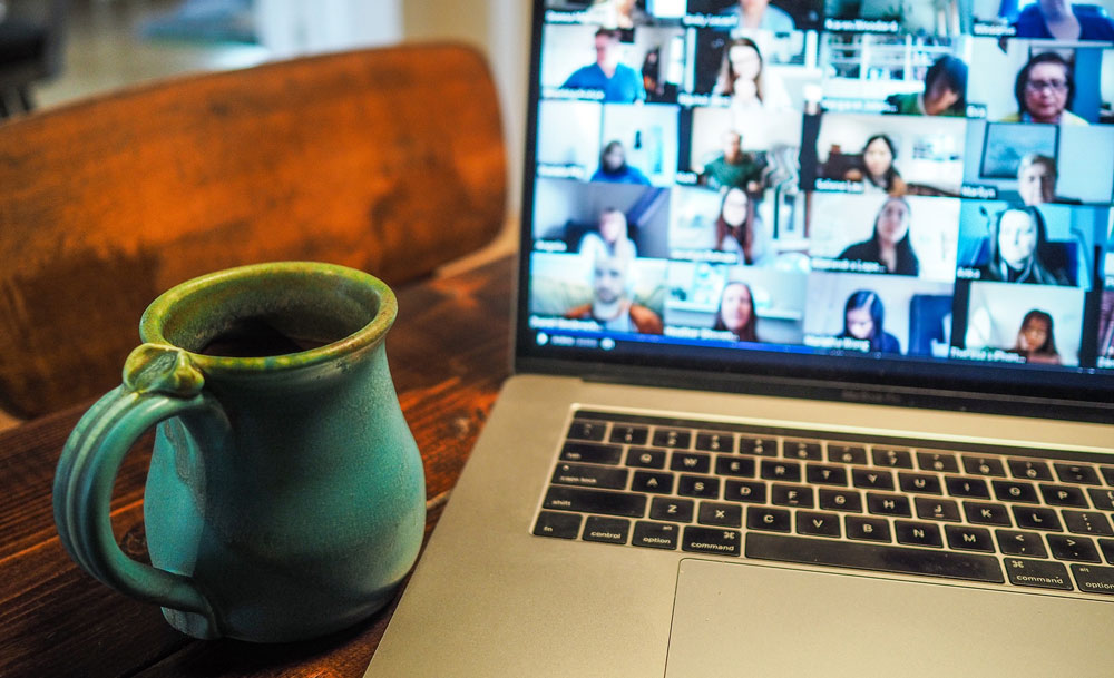 En laptop med videomöte och en kopp kaffe