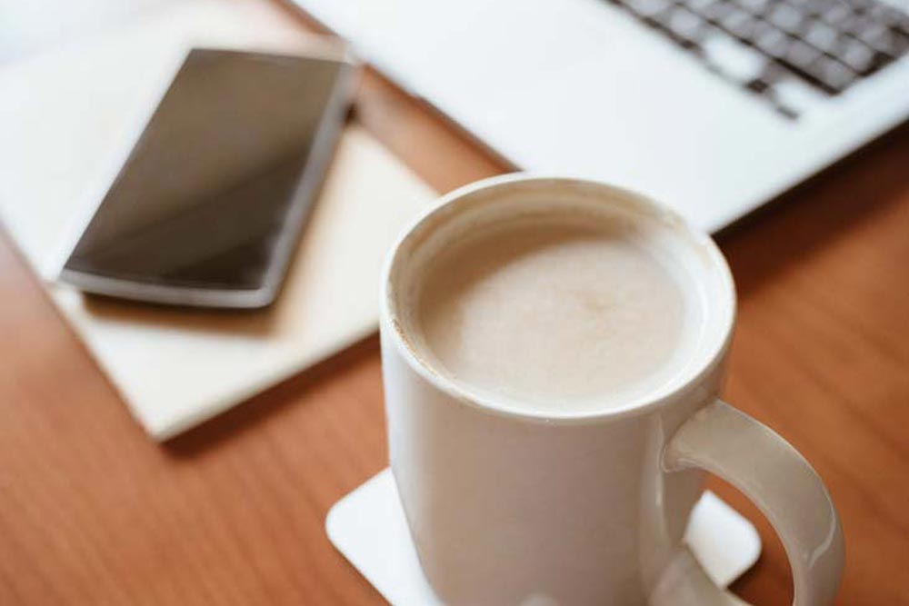 Kaffekopp vid dator.