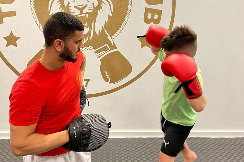 En man som lär upp ett barn att boxas.