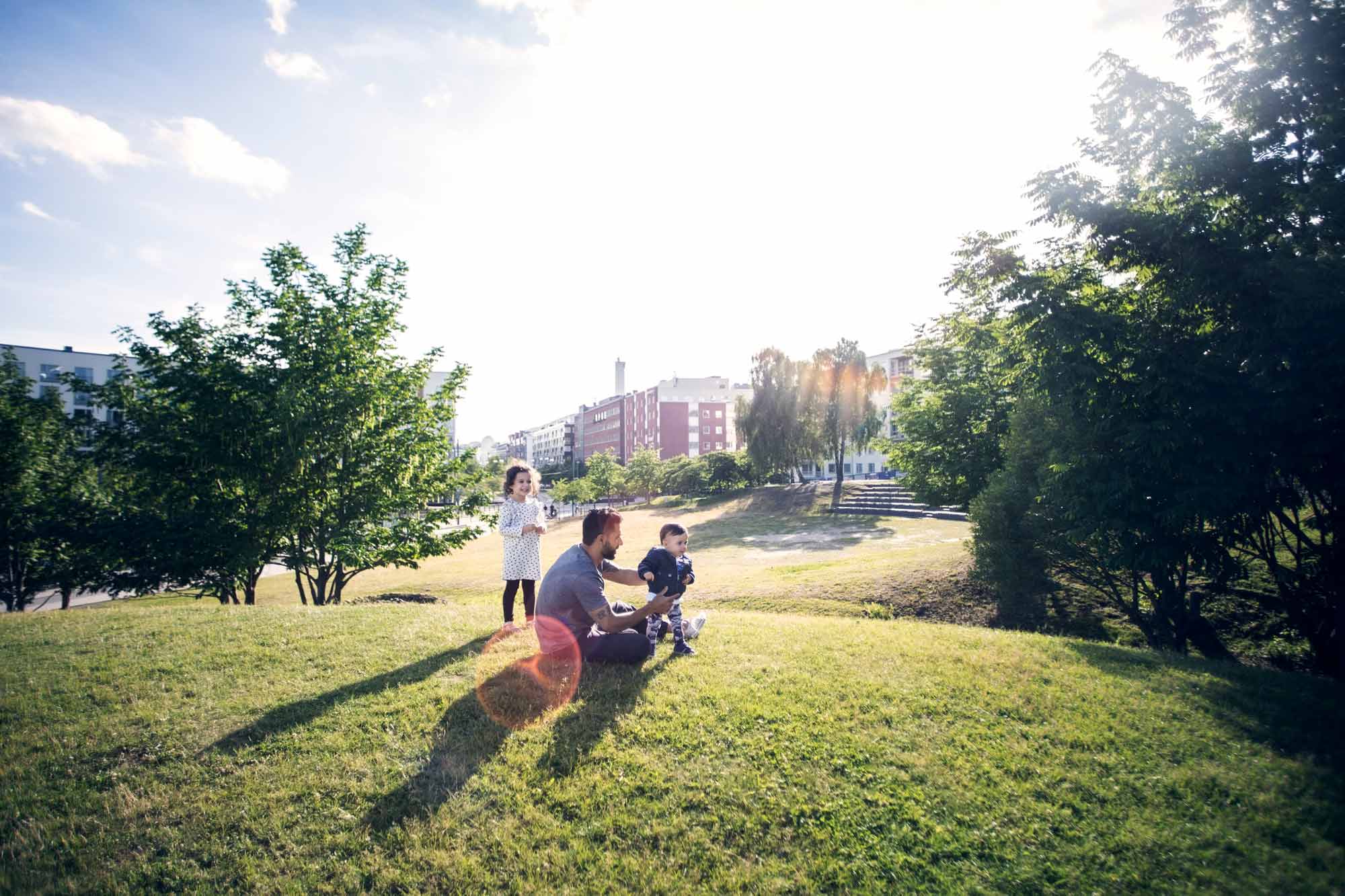 Personer som njuter av en välskött park i ett bostadsområde.