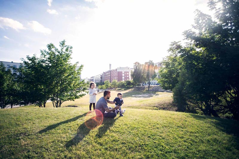 Personer som njuter av en välskött park i ett bostadsområde.
