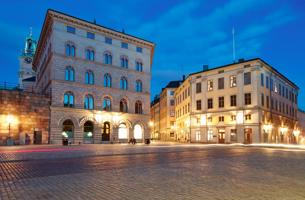 En storslagen bild av Stockholms slott och det angränsande stadstorget i Gamla Stan under blå timmen
