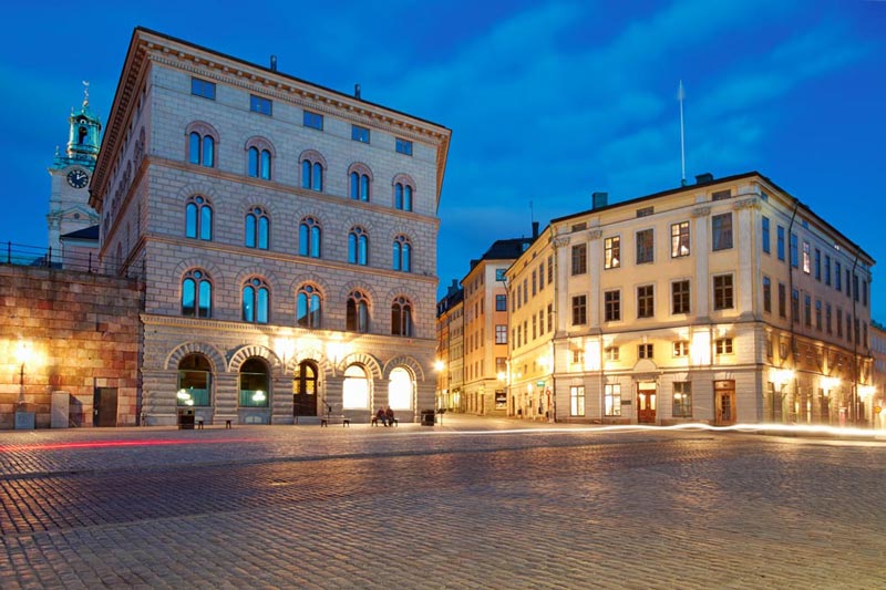En storslagen bild av Stockholms slott och det angränsande stadstorget i Gamla Stan under blå timmen