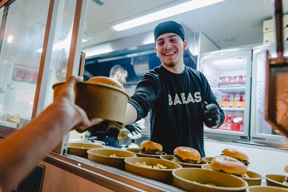 Personal från Babas som ger mat till en kund.